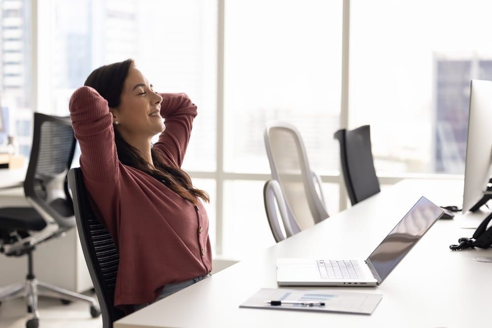 Carefree peaceful young woman project manager relax at workplace lean back in comfy chair